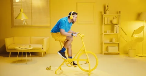 Slow motion of confident young man doing workout by riding an exercise bikes in Video stock 165867327