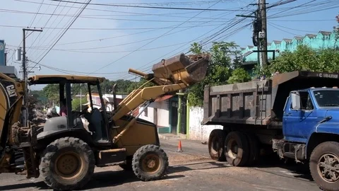 Slow motion construction of bulldozer putting dirt in truck in Guatemala Stock Footage 115431615