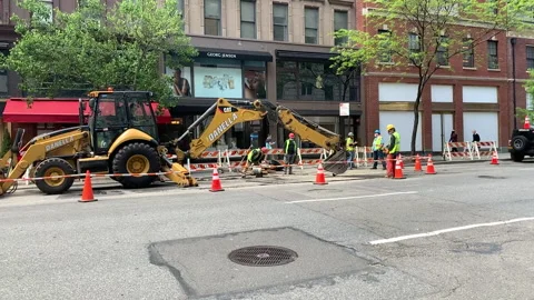 Slow motion: Construction Workers &amp; Equipment on the side of a city Street NYC Stock Footage 131102825