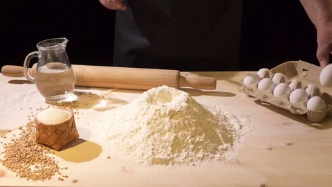 Slow motion.The cook breaks the egg into flour with a knife Video stock 76398480