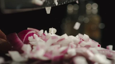 SLOW MOTION: Cook Cutting  A Head Of Fresh Red Onion On A Black Table Stock Footage 114797544