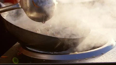 Slow motion: cook makes asian noodles in wok. a versatile round-bottomed cooking Stock Footage 53344393