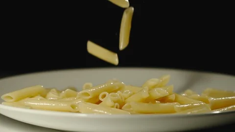 SLOW MOTION: Cooked penne rigate fall into full plate Vídeo Stock 100631928