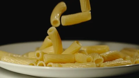SLOW MOTION: Cooked tortiglioni fall into full plate Stock Footage 100631965