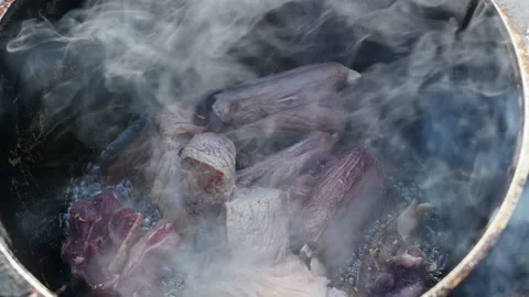 Slow motion of cooking beef meat in a cauldron on open fire Video stock 87209308