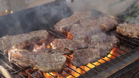 Slow motion of cooking beef steaks on a barbecue grill Stock Footage 97181629