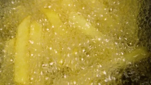Slow motion of cooking fried potatoes and taking out from boiling oil Stock Footage 76952713
