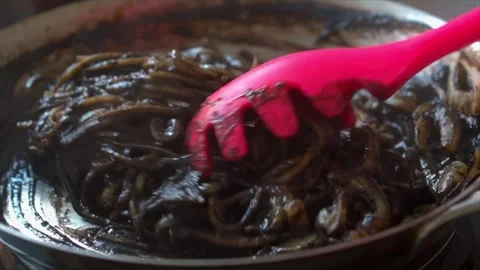 Slow motion of cooking Squid ink spaghetti in a frying  pan Stock Footage 249252050