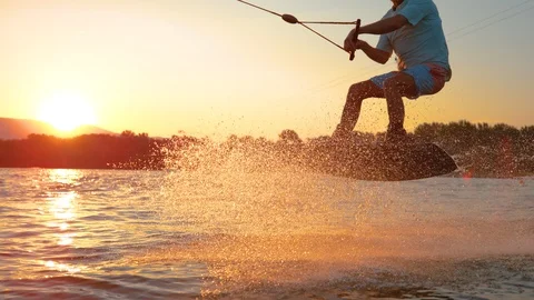 SLOW MOTION: Cool surfer dude does 180 ollie while wakeboarding on sunny evening Stock Footage 102867563