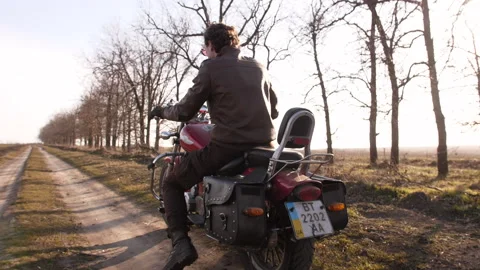 Slow motion of cool young biker, on red chopper, expressive looking back Stock Footage 152507451