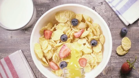 Slow motion corn flakes with berries pour liquid top view Stock Footage 93872739