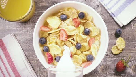 Slow motion corn flakes with berries pour liquid top view Stock Footage 93872797