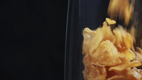 Slow motion of corn flakes falling into clear glass on black background Stock Footage 279700512