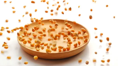 Slow Motion of Corn Kernels poured in wooden plate on white background Stock-Footage 143379119