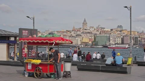 Slow Motion Corn Vendor at Red Street Cart with Galata Tower Skyline Stock Footage 347067561
