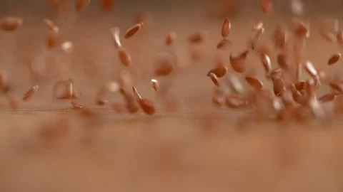 SLOW MOTION: Countless flax seeds raining from the sky onto the countertop. Stock Footage 103185717