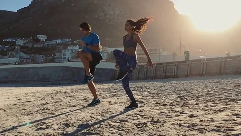 Slow motion couple exercising on beach Video stock 76521964