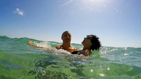 Slow motion of a couple having fun ans smiling together into the sea Stock Footage 91586474