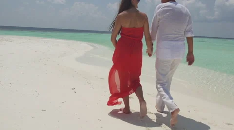 Slow Motion Of Couple Holding Hands And Playfully Jumping On White Sandy Beach Stock Footage 45857829