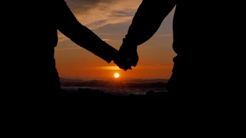 Slow motion couple joining hands together with sunlight in background Stock Footage 123967621