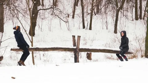 Slow Motion, Couple Man and Woman Ride on Homemade Swing in Snowy Forest Stock Footage 101406399