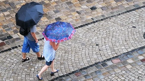Slow motion of couple walking in rain at old town market square in Lviv, Ukraine Stock Footage 112641671