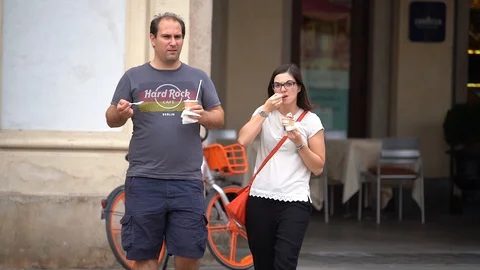 Slow motion of a couple that is walking while eating an ice cream Video stock 111877458
