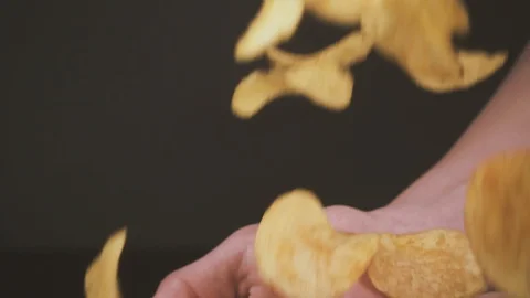 Slow motion crisps fall into the open palms of the boy Stock Footage 87794767