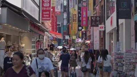 Slow motion of crowd entering Myeongdong alley full of shops and signs Stock Footage 315465104