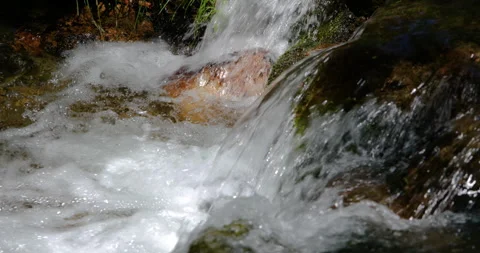 Slow motion crystal clear river flowing over granite stone 4k 100fps Stock Footage 336389558