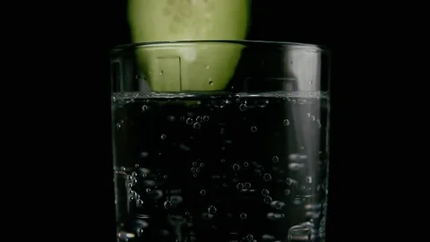 Slow motion. A cucumber slice falls into a glass Stock Footage 75716164