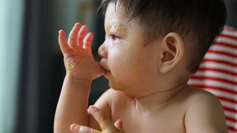 Slow-motion, cute baby using finger hand in mouth itchy gum first primary tooth Stock Footage 86948992