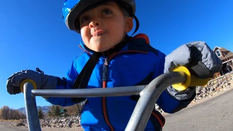 Slow motion of a cute boy riding his little bike in the cold with gloves Stock Footage 100746801