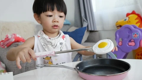 Slow motion, cute child playing toy kitchenware cooking food Stock Footage 96006711