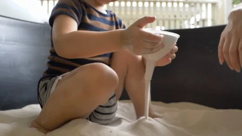 Slow motion cute child playing sand falling in toy Stock Footage 114012624