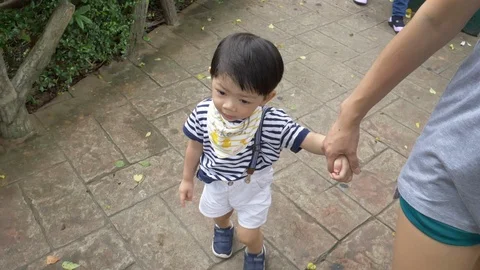 Slow motion cute child walking with hand holding mom Video stock 109499221