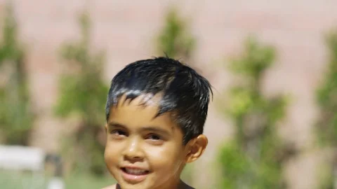 Slow Motion of cute little boy shaking water off while smiling at the camera. Stock Footage 92223078