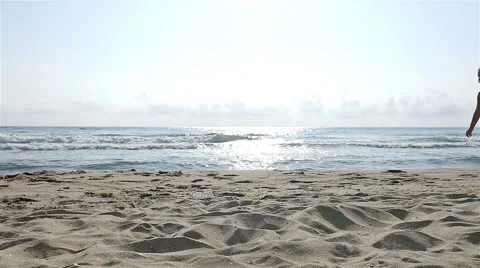 Slow motion of a cute little girl in swimsuit playing at the sea beach Stock Footage