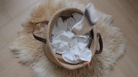 Slow Motion of cute ribbed socks are filling into a laundry basket on a floor 스톡 동영상 124709352