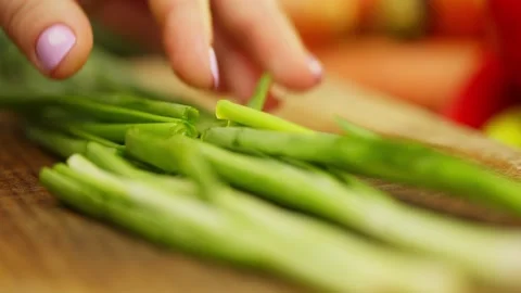 Slow motion of cutting a bunch of green onions with a knife on a cutting board Stock Footage 296362966