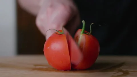 In slow motion, cutting a tomato into 2 parts. On the kitchen. Macro shot Stock Footage 131320476
