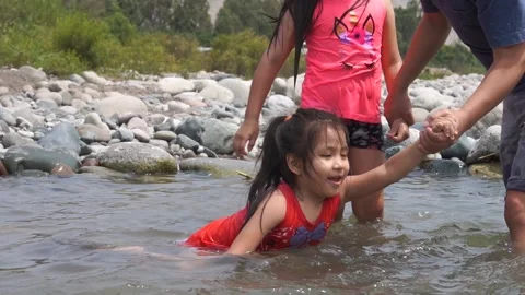 Slow motion of a dad holding his daughter to play with the water Stockbeeldmateriaal 150921218