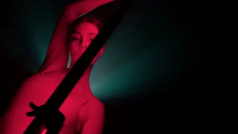 Slow motion dancing girl with red light tube in colored art space with smog Stock Footage 242911653