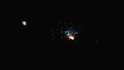 Slow motion dark blur shot of glowing flame particle flying from metal welding Video stock 102573243