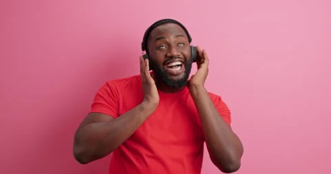 Slow motion. Dark skinned bearded man moves carefree keeps hands on headphones Stock Footage 150298263