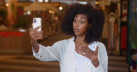 Slow motion: dark skinned lady enjoys distance communication, uses smartphone Stock Footage 230399377