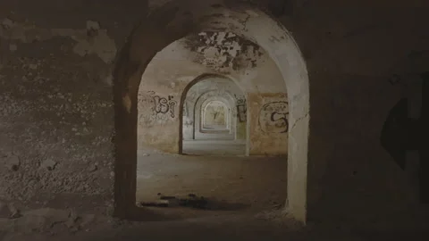 Slow motion dark, symmetrical empty corridor with graffiti covered walls. Old Stock Footage 155449529