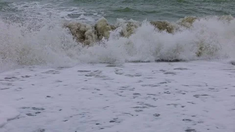 Slow motion dark waves crashing onto the shore line Video stock 313526872