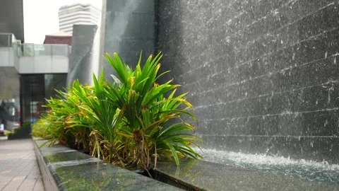 Slow motion of decorative cascade waterfall stone wall on the city street Stock Footage 289180175