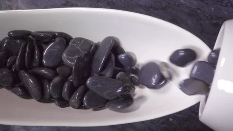 Slow motion – Decorative pebbles pouring into a display bowl. Stock Footage 119603434